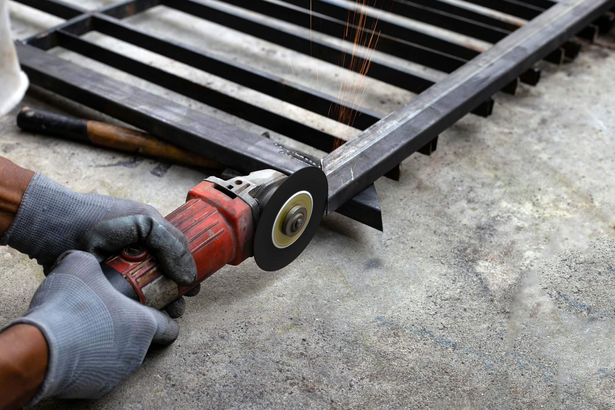 Close up, A man working with angle grinder. Iron gate repair